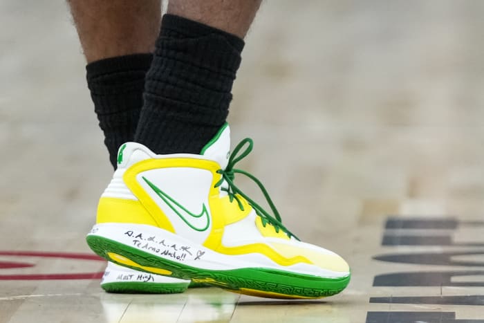 View of white, yellow, and green Kyrie Infinity shoes.